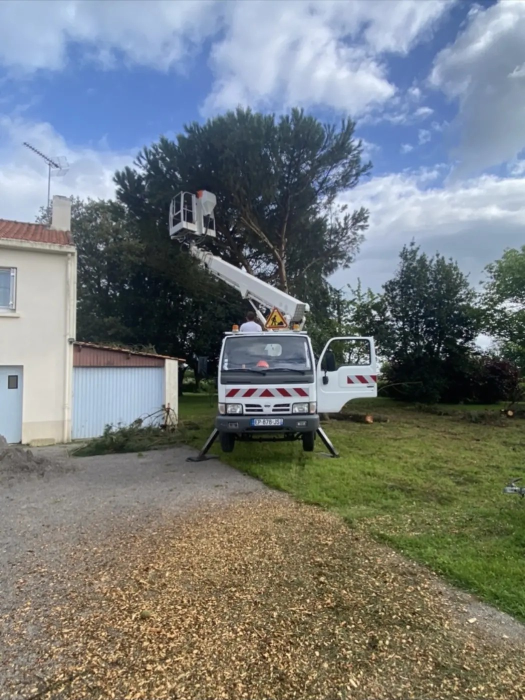 Nacelle d'Élagage Vogel installée dans l'allée d'un jardin